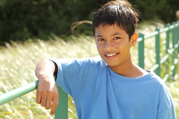 Хлопчик на паркані в сільській місцевості — стокове фото