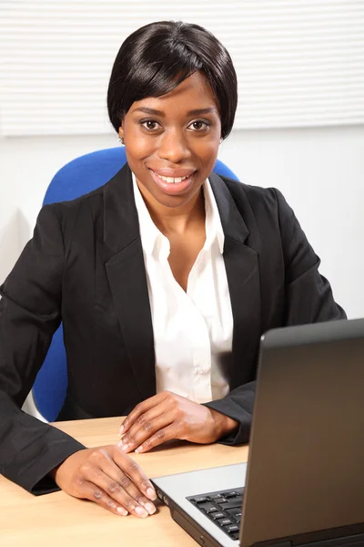 Szczęśliwy piękna czarna kobieta korzysta z laptopa w biurze — Zdjęcie stockowe