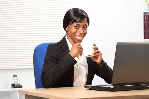 Piękna czarna kobieta pije kawę w pracy — Zdjęcie stockowe