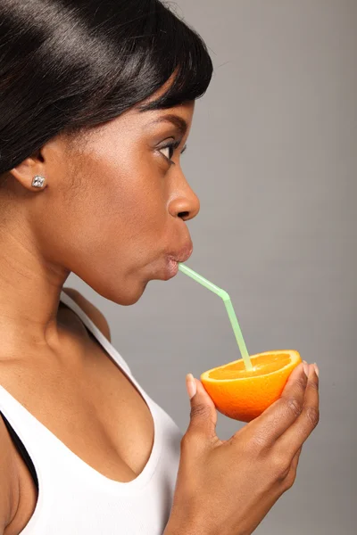 Piękne african american kobieta z owoców pomarańczy — Zdjęcie stockowe