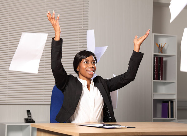 Счастливая красивая деловая женщина бросает бумагу в воздух
