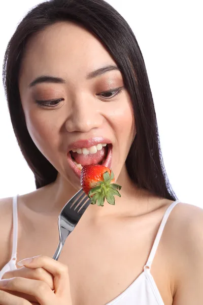 Menina adolescente chinesa bonita comendo morango — Fotografia de Stock