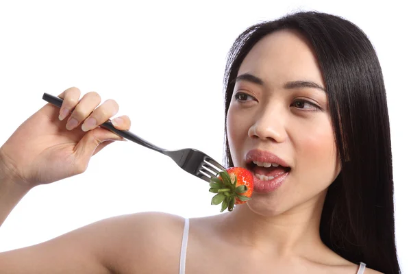 Exotic beautiful oriental girl eating strawberry — Stock Photo, Image