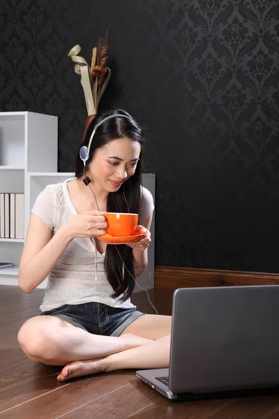 Beautiful chinese girl drinking tea using internet — Stock Photo, Image