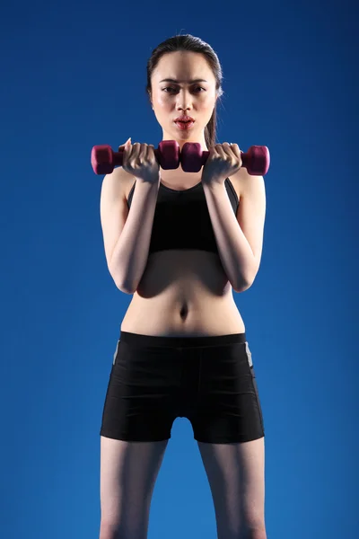 Fit young oriental woman lifting exercise weights — Stock Photo, Image