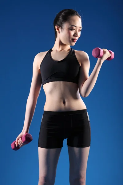 Mulher oriental bonita levantando pesos fitness — Fotografia de Stock