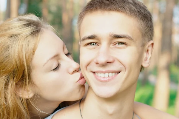 Teenage boy kissed by his girlfriend — Stock Photo, Image