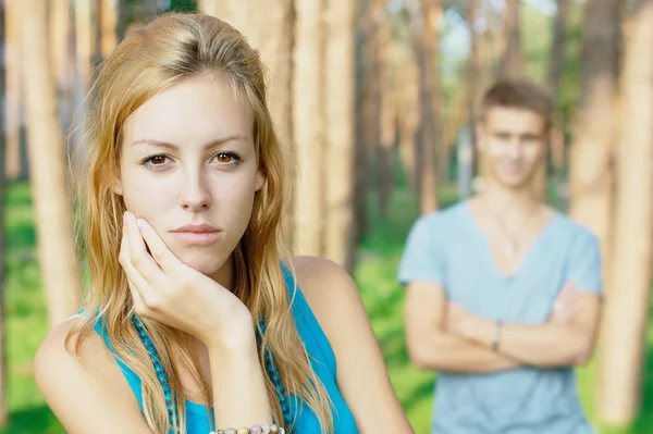 Upset teenage girl and a boy a thte background — Stock Photo, Image