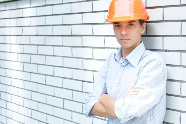 Young worker standing near a wall — Stock Photo, Image