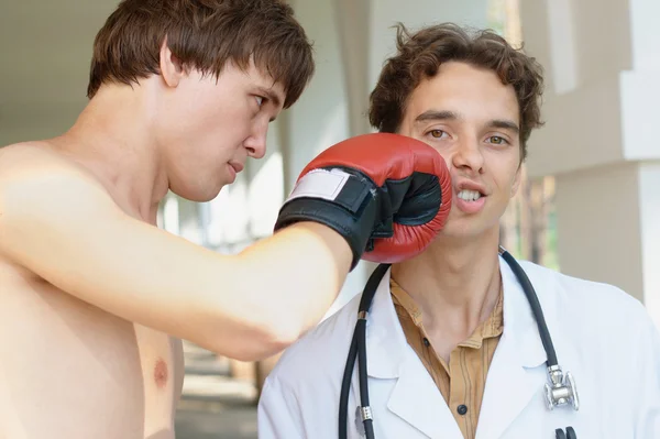 医生从一个拳击手接收一拳 图库图片