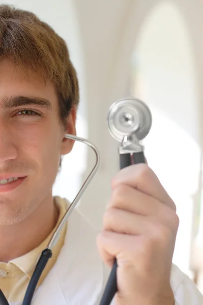 Jeune médecin souriant tenant un stéthoscope — Photo