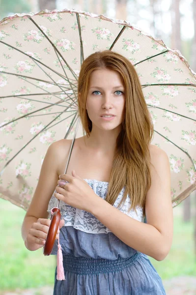 Krásná mladá dívka s deštníkem v parku — Stock fotografie
