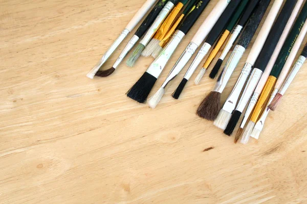 Artist piant brushes on vertical pine wood background — Stock Photo, Image