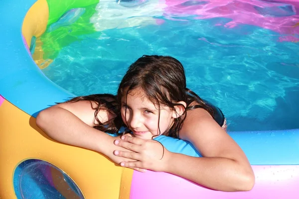 Νεαρό κορίτσι που παίζει στην παιδική πισίνα, την ηλιόλουστη ημέρα Royalty Free Εικόνες Αρχείου