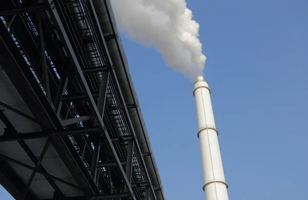 Pipelines and smokestack against blue sky — Stock Photo, Image