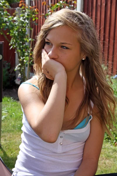 Красивая девочка-подросток в саду нервничает — стоковое фото