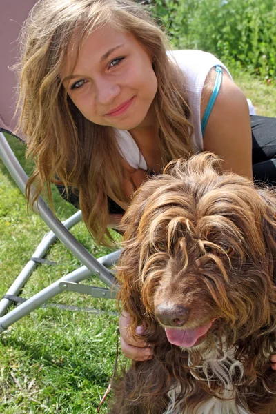 Onu evde beslenen hayvan köpek ile çarpıcı genç kız — Stok fotoğraf