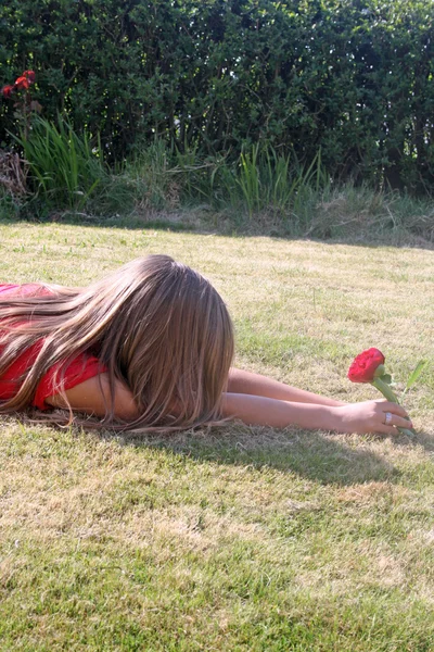 Εφηβικό κορίτσι με το κόκκινο λουλούδι — Φωτογραφία Αρχείου