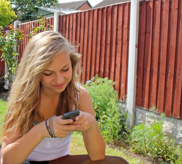 Mädchen SMS auf Mobiltelefon lizenzfreie Stockbilder