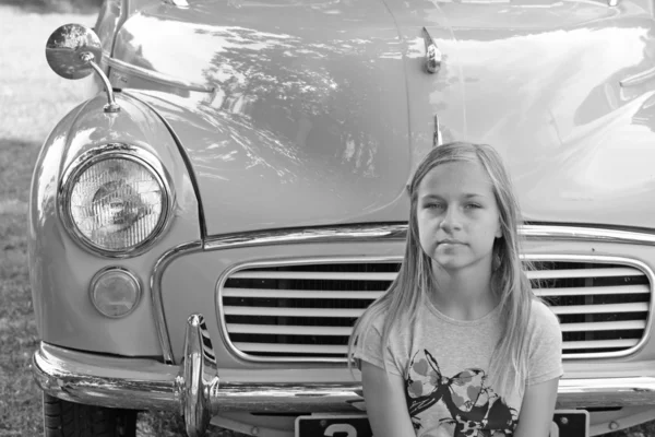 Dziewczyna usiadł w pobliżu klasyczny samochód — Zdjęcie stockowe