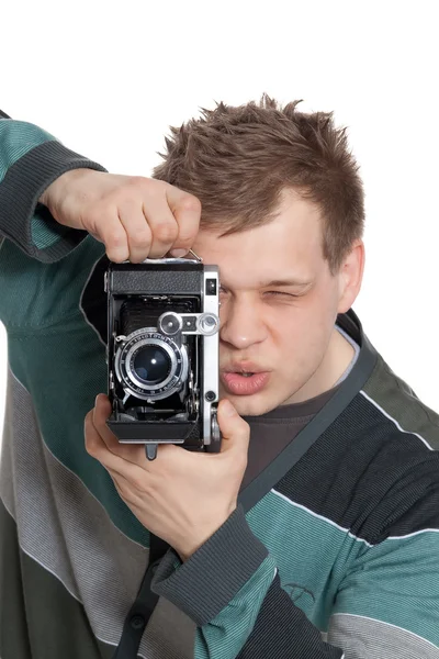 젊은 남자는 오래 된 카메라에 촬영 초점을 맞추고합니다 — 스톡 사진
