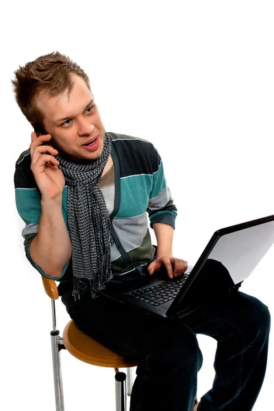 Jeune homme avec ordinateur portable et téléphone portable — Photo