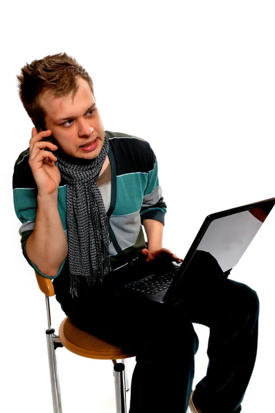 Laptop ve cep telefonlu genç adam. — Stok fotoğraf