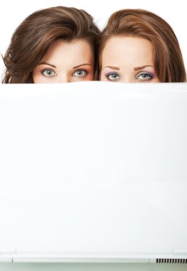 Girls peeking behind laptop clipart