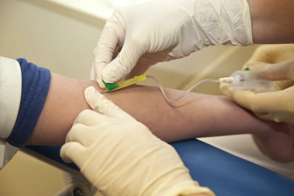 Krankenschwester nimmt einem Kind Blut ab — Stockfoto