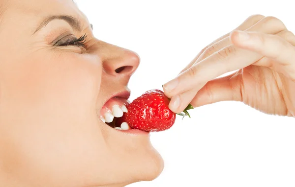 Woman biting strawberry — Stock Photo, Image