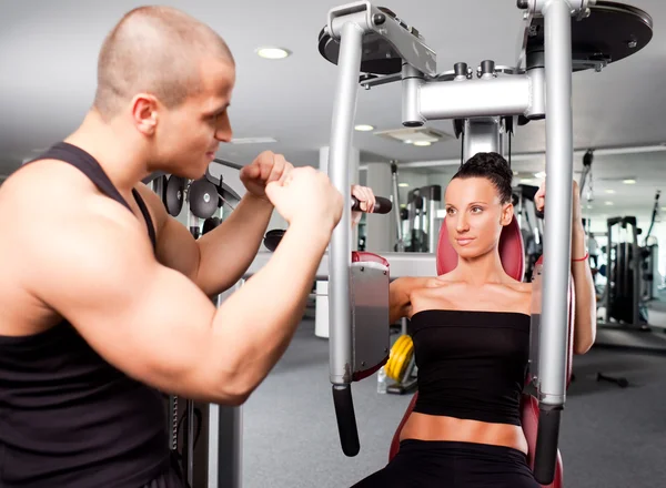 Weibchen im Fitnessstudio mit Trainer — Stockfoto