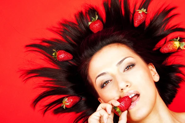 Frau beißt auf Erdbeere — Stockfoto