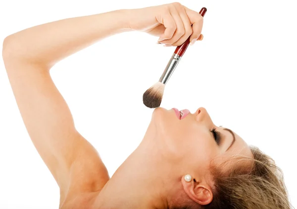 Perfil de una hermosa hembra sosteniendo un cepillo de maquillaje — Foto de Stock