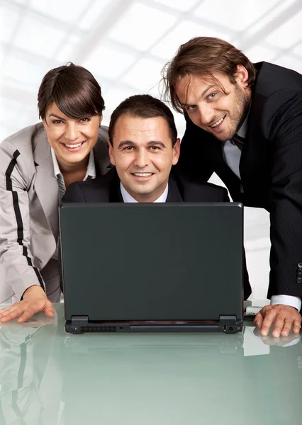Χαρούμενος συναδέλφους πίσω από ένα φορητό υπολογιστή — Φωτογραφία Αρχείου