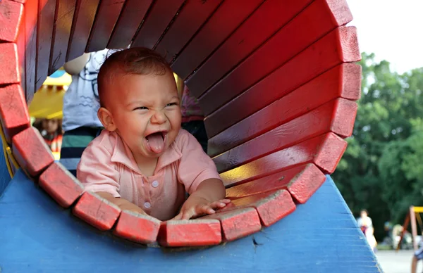 Happy kid in a playground tunnel — Stock Photo, Image