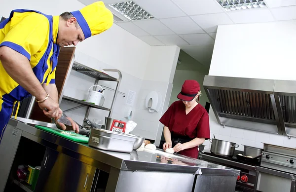 Couple of cooks in a restaurant kitchen — Stock Photo, Image