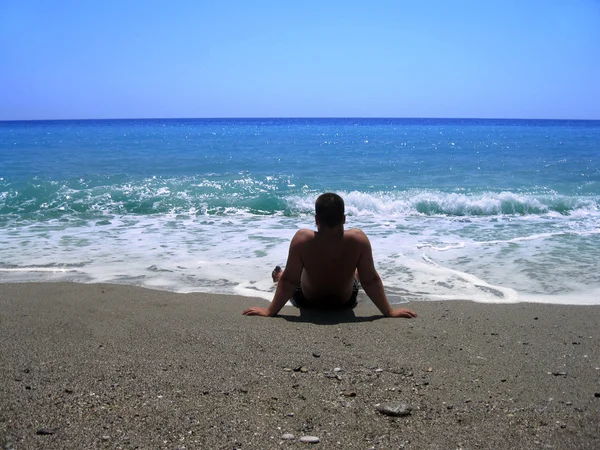 adam sahilde denize bakarak