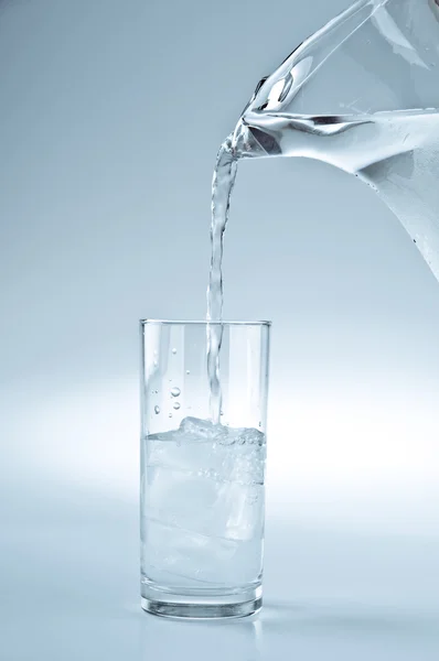Acqua versata dalla brocca al bicchiere — Foto Stock
