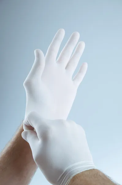 Doctor putting on protective gloves — Stock Photo, Image