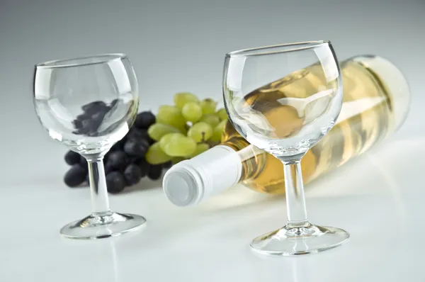 Bottiglia di bianco, due bicchieri vuoti e uva — Foto Stock