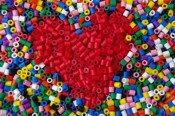 Coração arranjado com contas coloridas — Fotografia de Stock