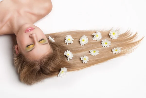 Aantrekkelijke jonge vrouw liggen bedekt met bloemen — Stockfoto