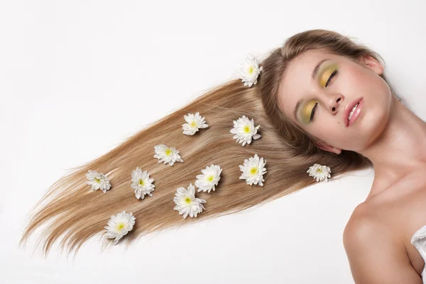 Jolie jeune femme couchée couverte de fleurs — Photo