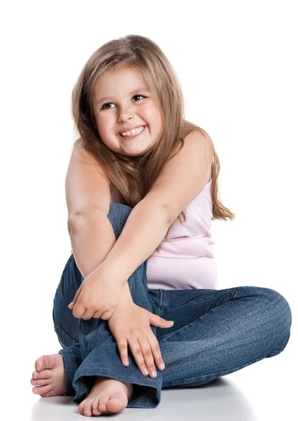Cute happy little girl sitting on white background — Stock Photo, Image