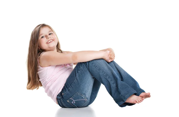 Aranyos boldog kis lány ül a fehér háttér — Stock Fotó