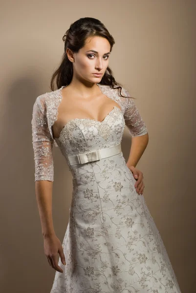 The beautiful young woman posing in a wedding dress — Stock Photo, Image