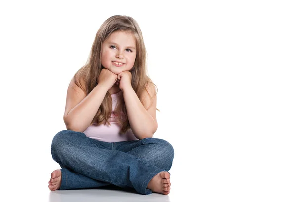 Cute happy little girl sitting on white background — Stock Photo, Image
