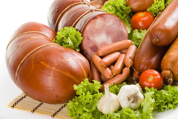 stock image Sausages and ham with lettuce, garlic and tomatoes