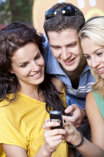 Group of friends reading message on a mobile phone — Stock Photo, Image