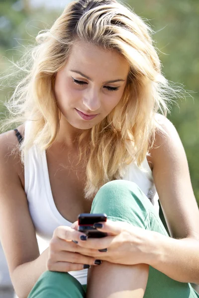 Young women reading a message on a mobile phone — Stock Photo, Image